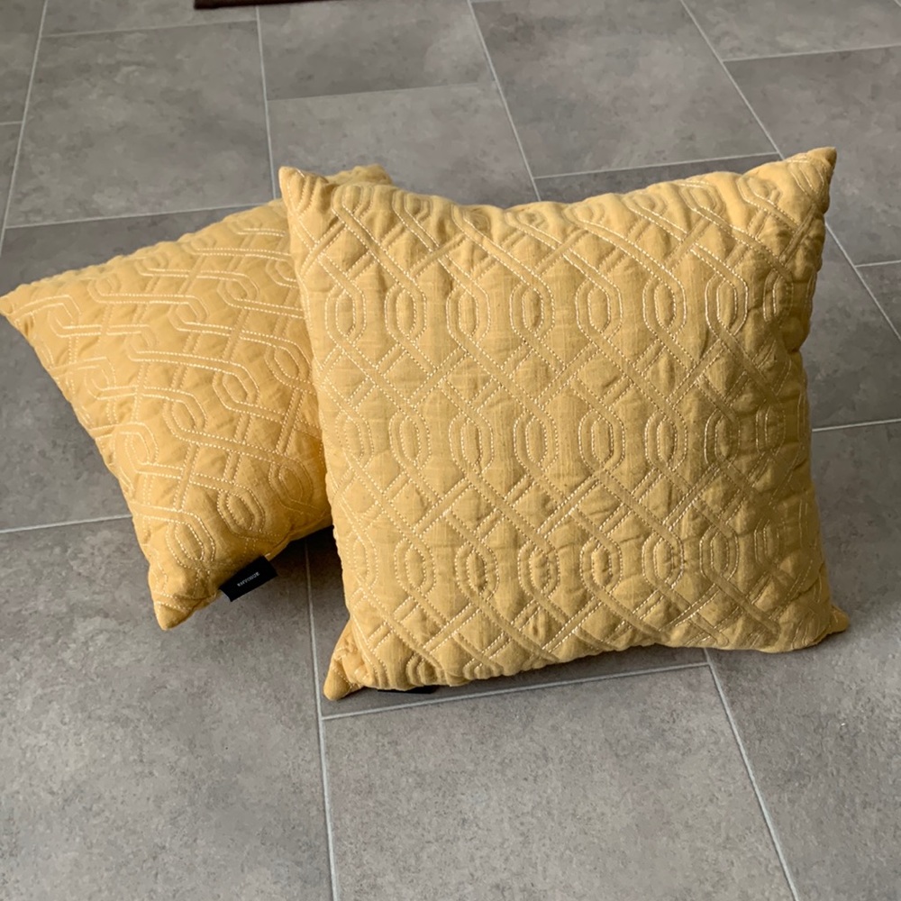Mustard yellow decorative pillows with white design